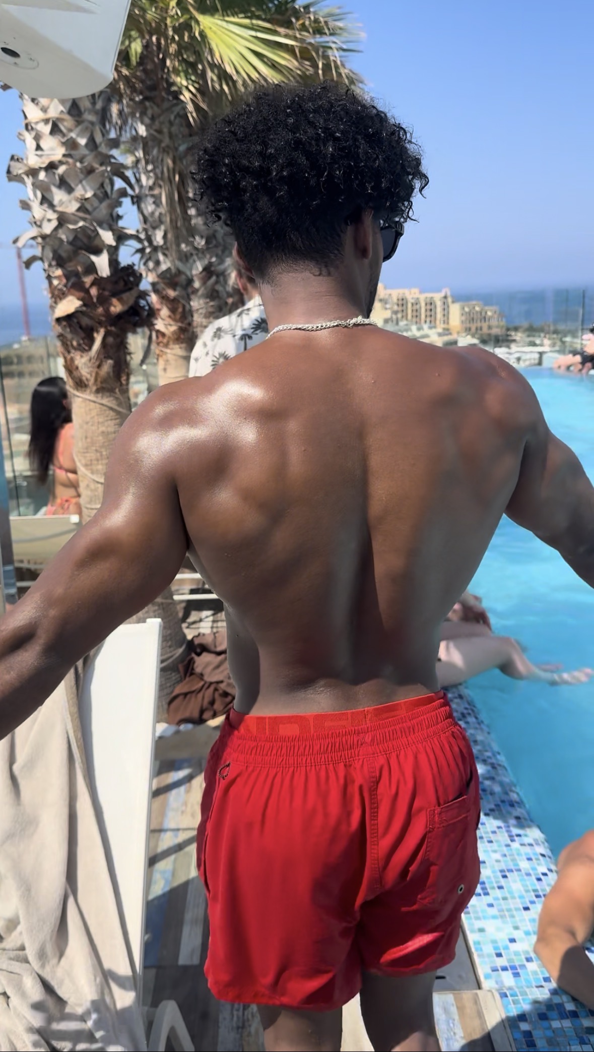 Deyron en extérieur, dos musclé face à la piscine